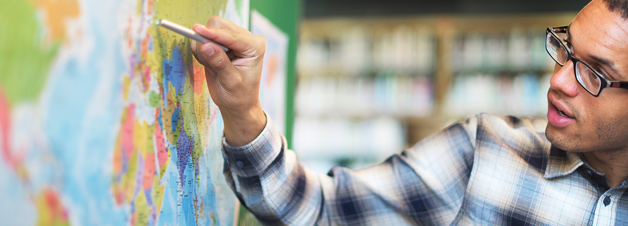 An educator points to a location on a map.